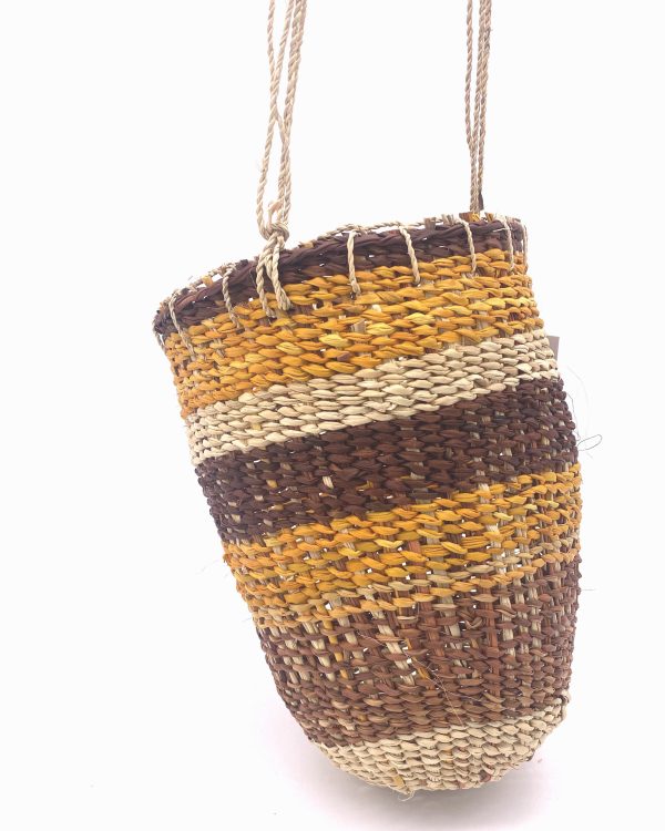 pandanus dilly bag, a cylindrical bag with rows of different coloured pandanus in brown, yellow and natural with a natural string handle