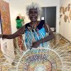 Betty Milikens, Aboriginal artist, with pandanus mats at Songlines Darwin