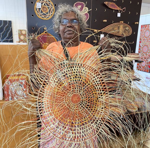 Marelene Yalandj holding a pandanus mat weaving in Songlines Gallery Darwin