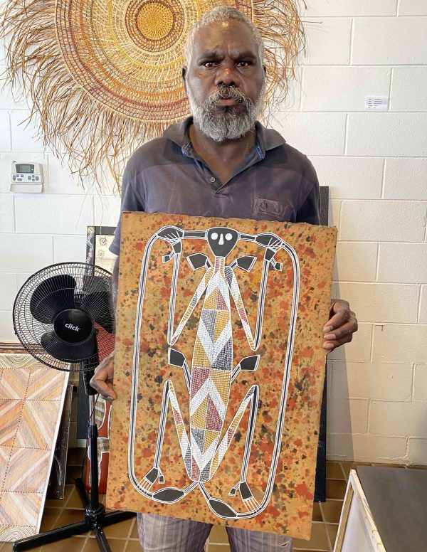 Lawrence Nganjmirra with a painting of Namarrkon on arches paper