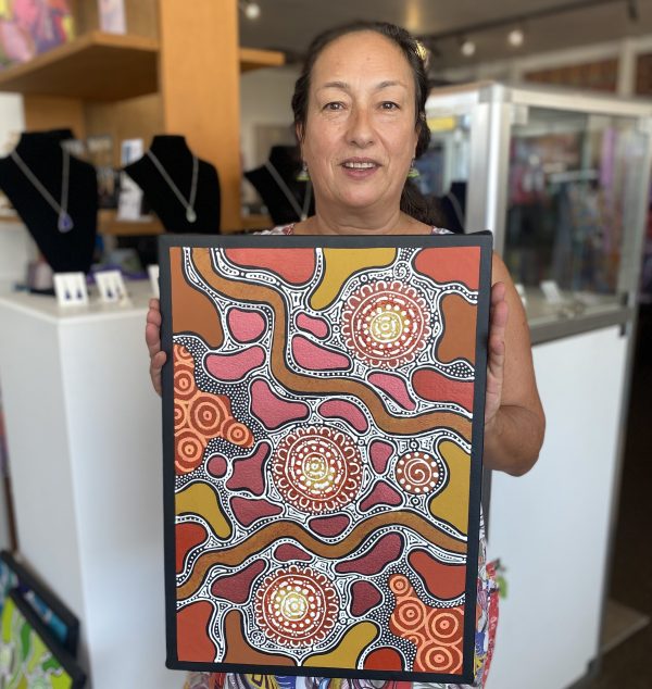Marie Napurulla holding her dot painting called Grandmothers Journey at Songlines Darwin